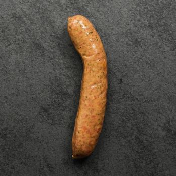 overhead shot of a raw mild Italian chicken sausage on black slate