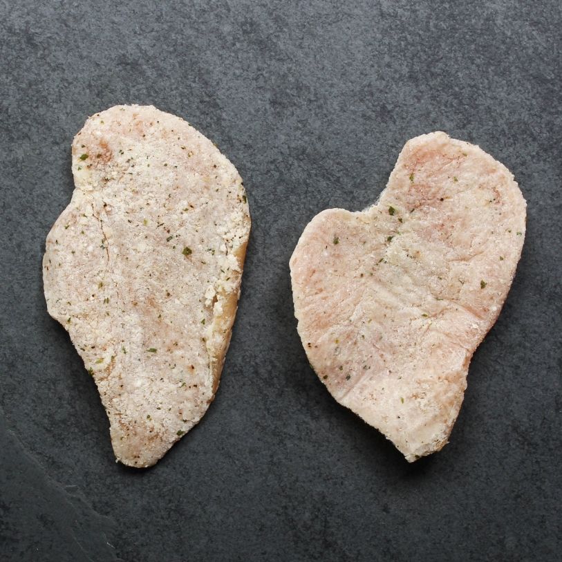 overhead view of two, raw, lightly breaded chicken breast cutlets