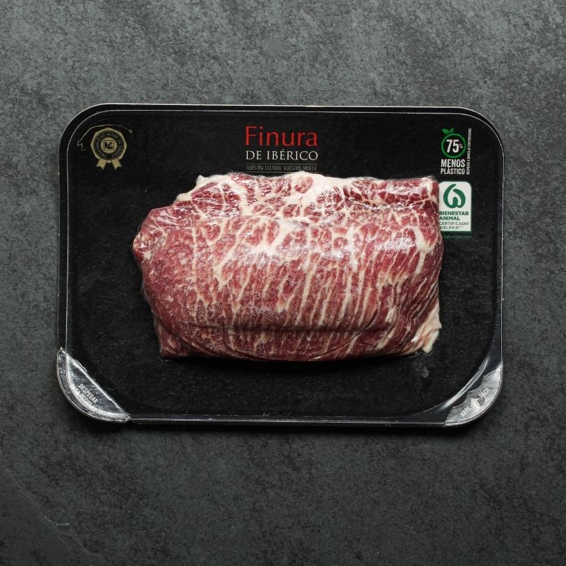 overhead view of raw iberico presa on black slate