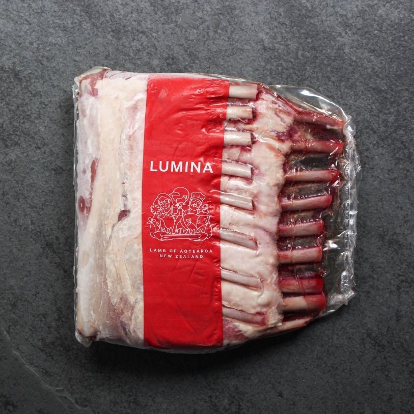 overhead shot of two raw, frenched lamb racks in vacuum packaging with Lumina lamb logo
