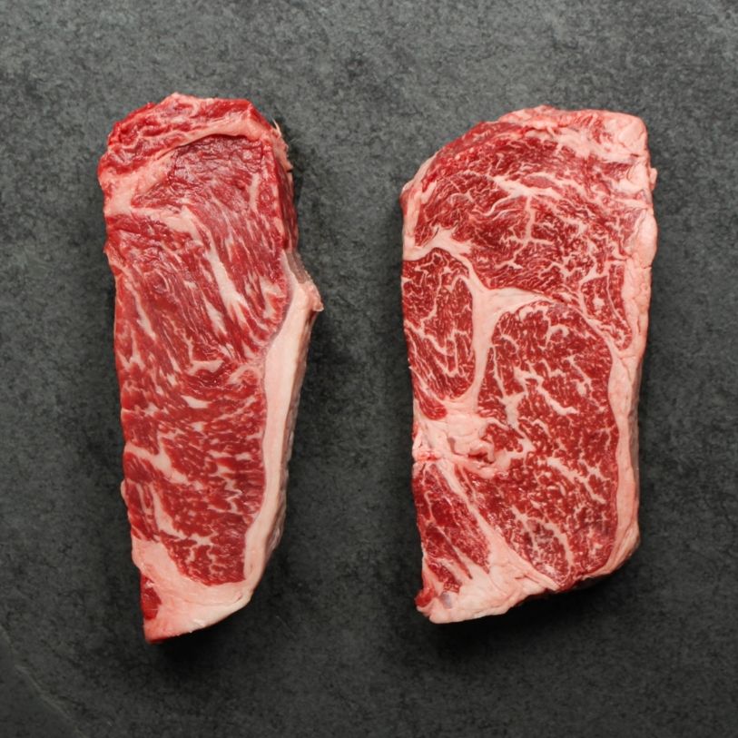 overhead view of a raw New York steak and ribeye steak