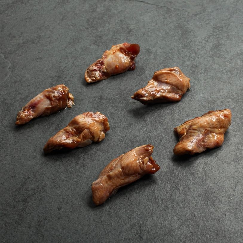 angled view of 6 raw, honey-garlic marinated chicken fryer drumettes
