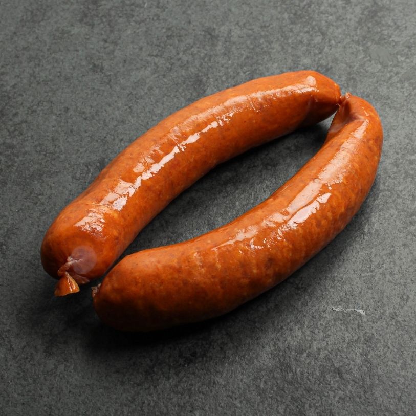 angled view of two, raw european style hot honey sausages