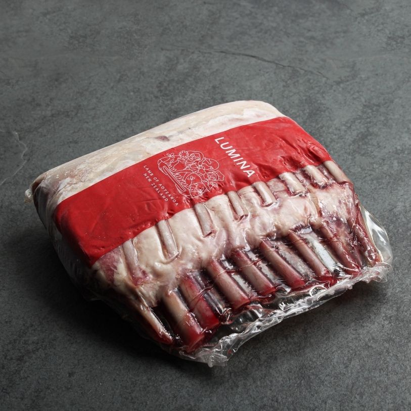 angled shot of two raw, frenched lamb racks in vacuum packaging with Lumina lamb logo