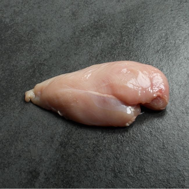 angled view of one, raw boneless skinless chicken breast