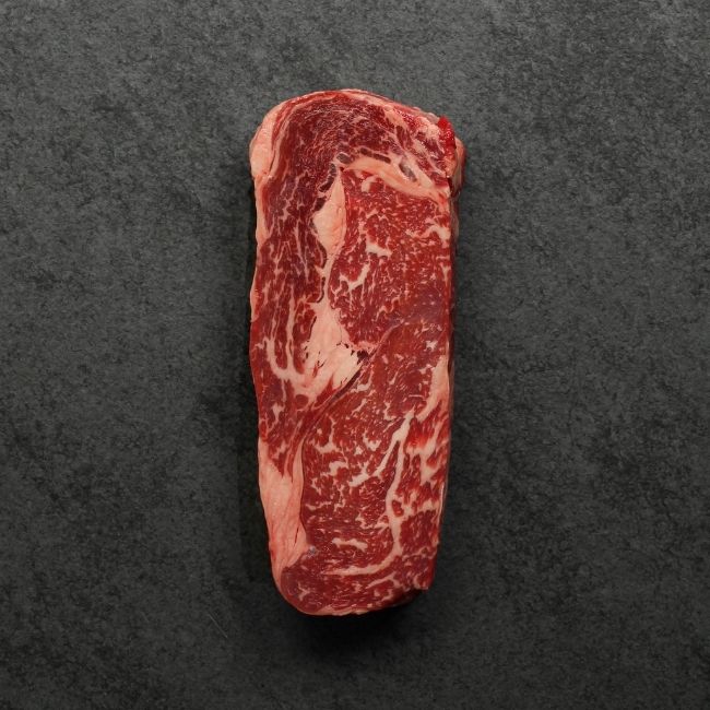 overhead view of a raw, well-marbled grass fed ribeye steak