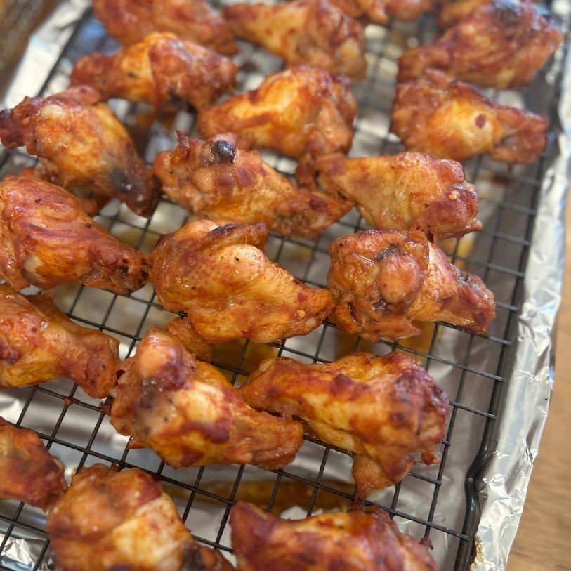 honey garlic chicken drumettes on a wire rack over a baking sheet