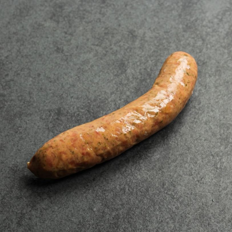 angled shot of a raw mild Italian chicken sausage on black slate