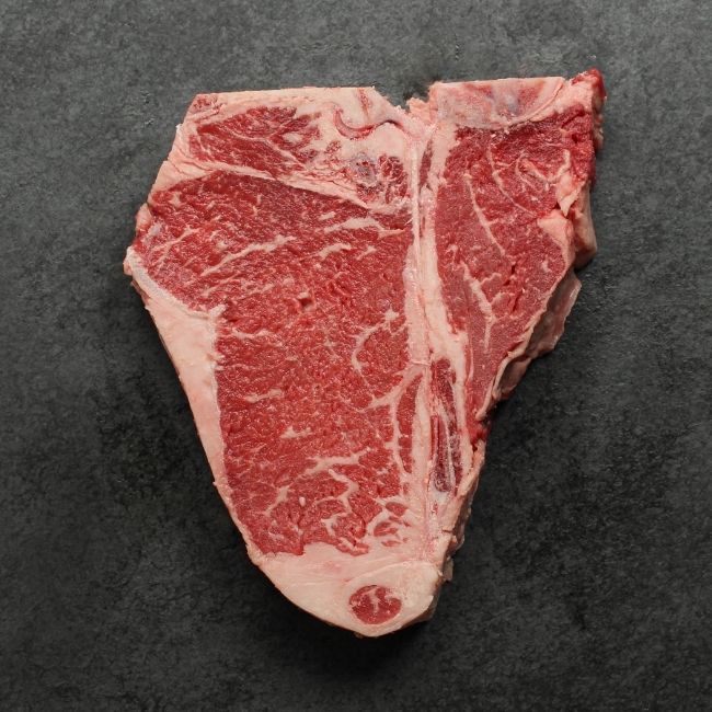 Bottom side of raw t-bone steak.
