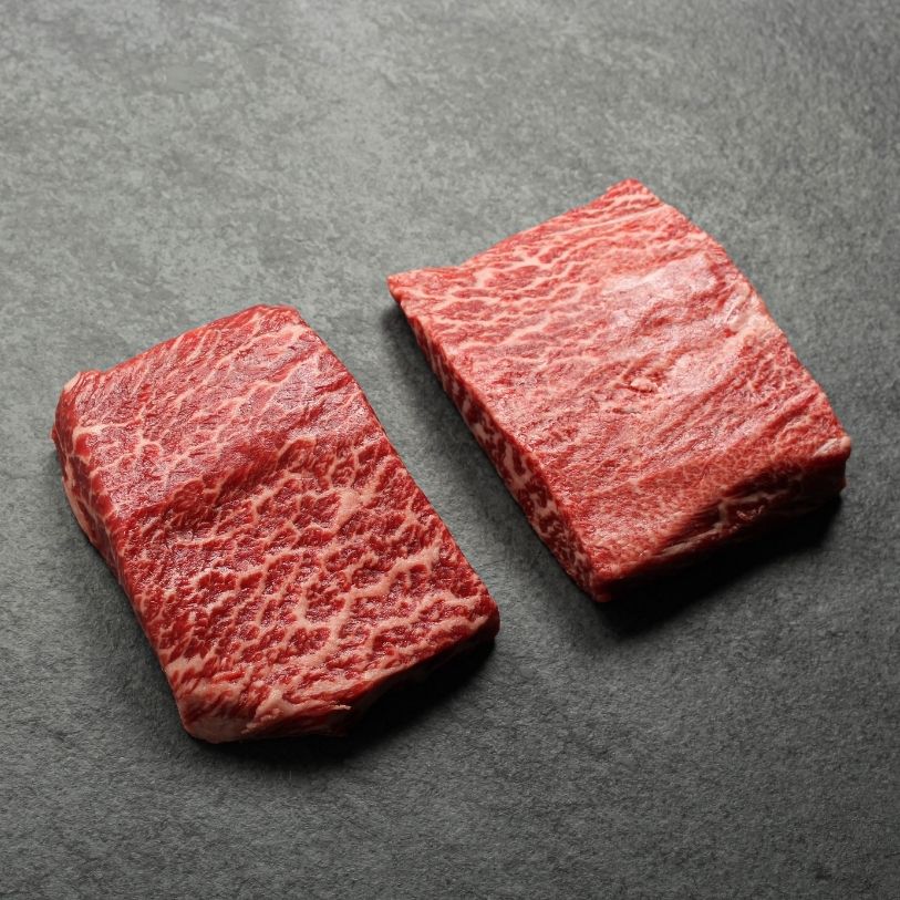 angled view of two, heavily marbled wagyu flat iron steaks