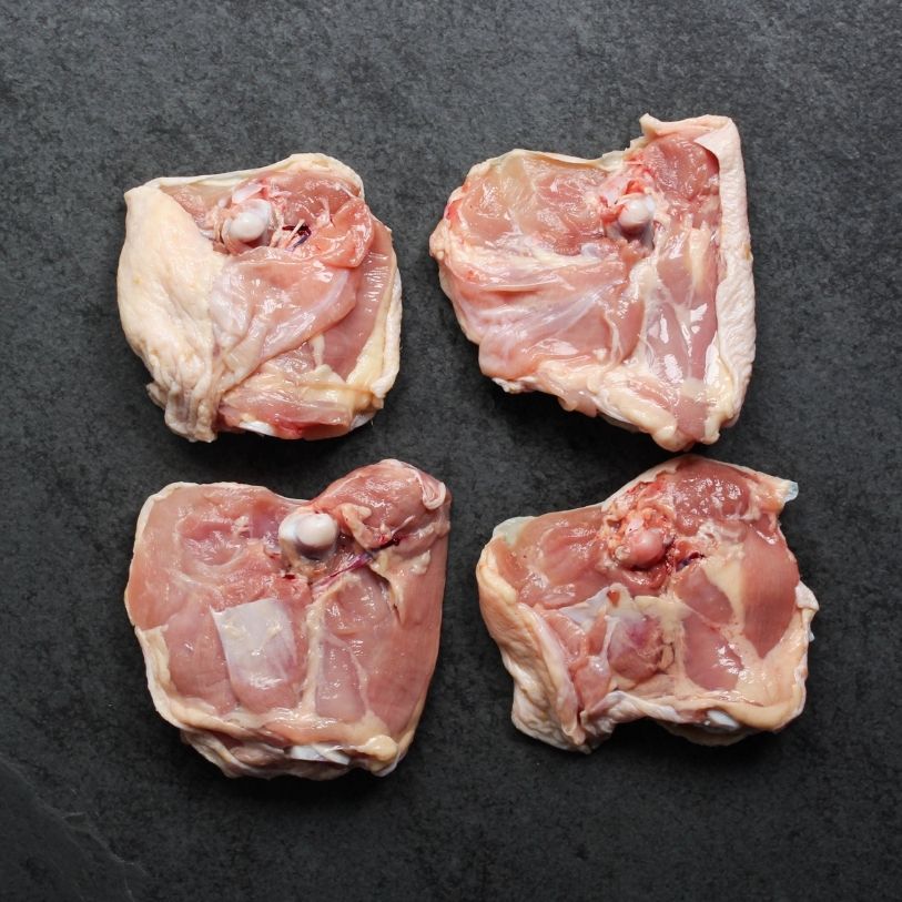 overhead view of the underside of 4 raw bone-in, skin-on chicken thighs