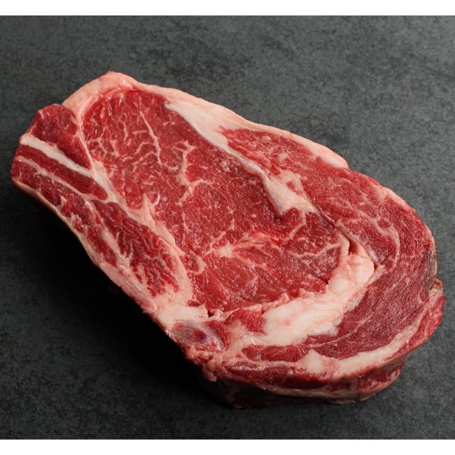 close up of raw bone-in rib steak