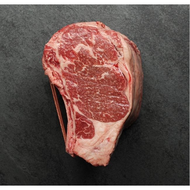 side view of a raw capless prime rib roast with the back bones removed and tied back on