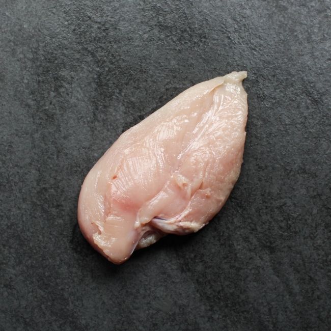 angled view of one, raw boneless skinless chicken breast