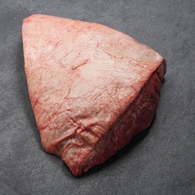 angled view of the fat cap side of a whole raw picanha roast