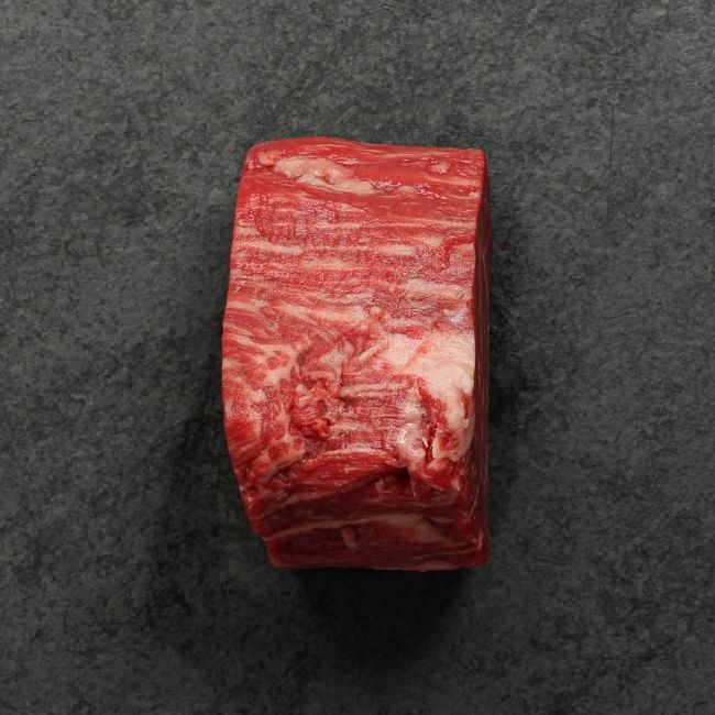 side view of a raw heavily marbled American-wagyu beef hybrid filet mignon