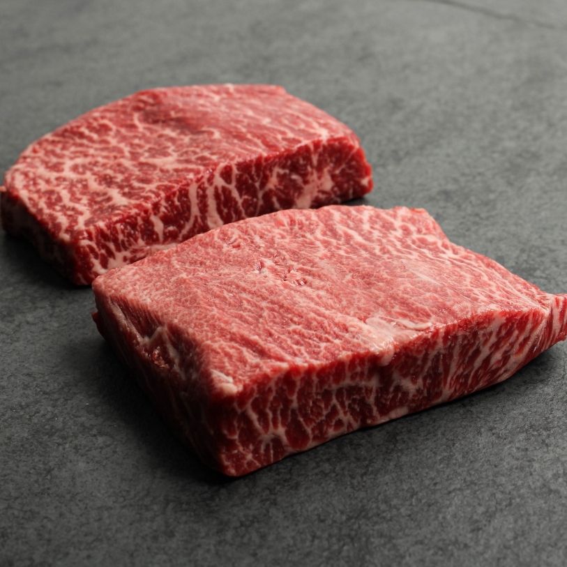 angled view of two, heavily marbled wagyu flat iron steaks