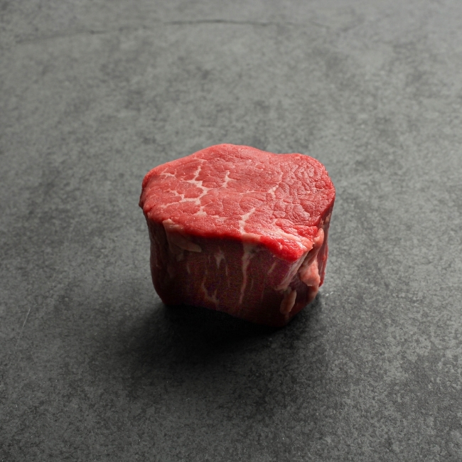 angled view of a raw, Canadian Prime 4 oz filet mignon steak