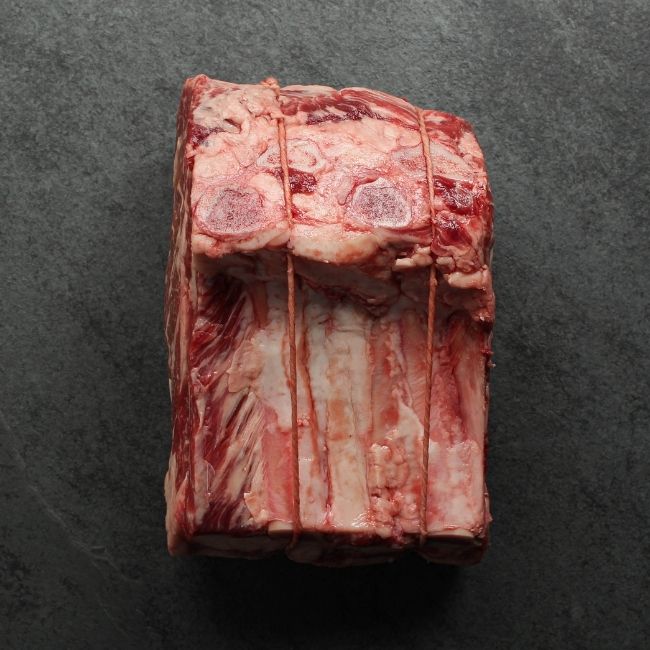 overhead view of a raw capless prime rib roast with the back bones removed and tied back on