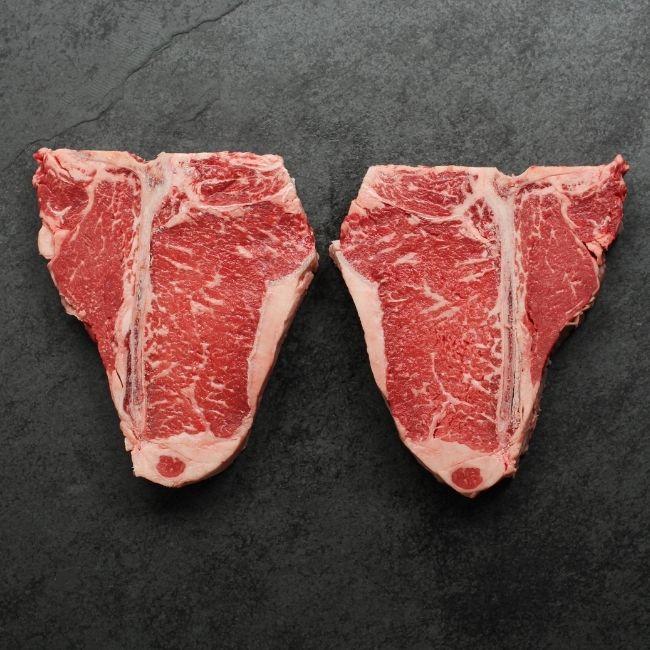 Overhead view of two t-bone steaks.