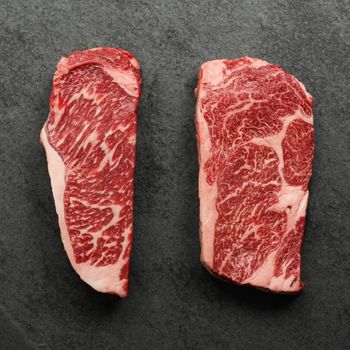 overhead view of a raw New York steak and ribeye steak